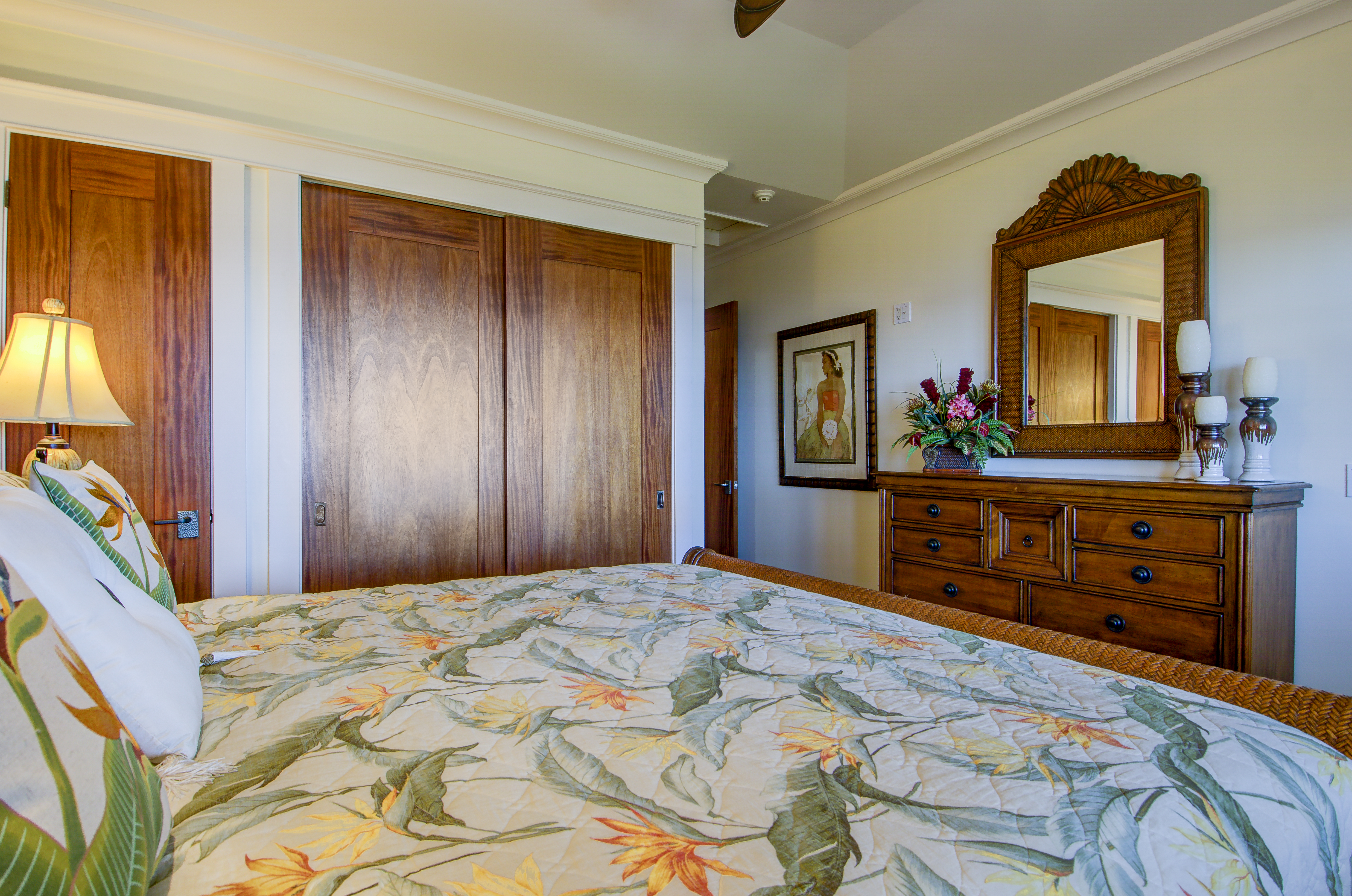 Honu La'e's second bedroom with king bed, featuring deep wood furniture and accents.