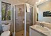 Koa Cottage bathroom off the main living area across from the second bedroom features garden views and a large, walk-in, glass surround shower.