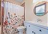 Floral curtain graces tub/shower in bathroom of master bedroom #3.