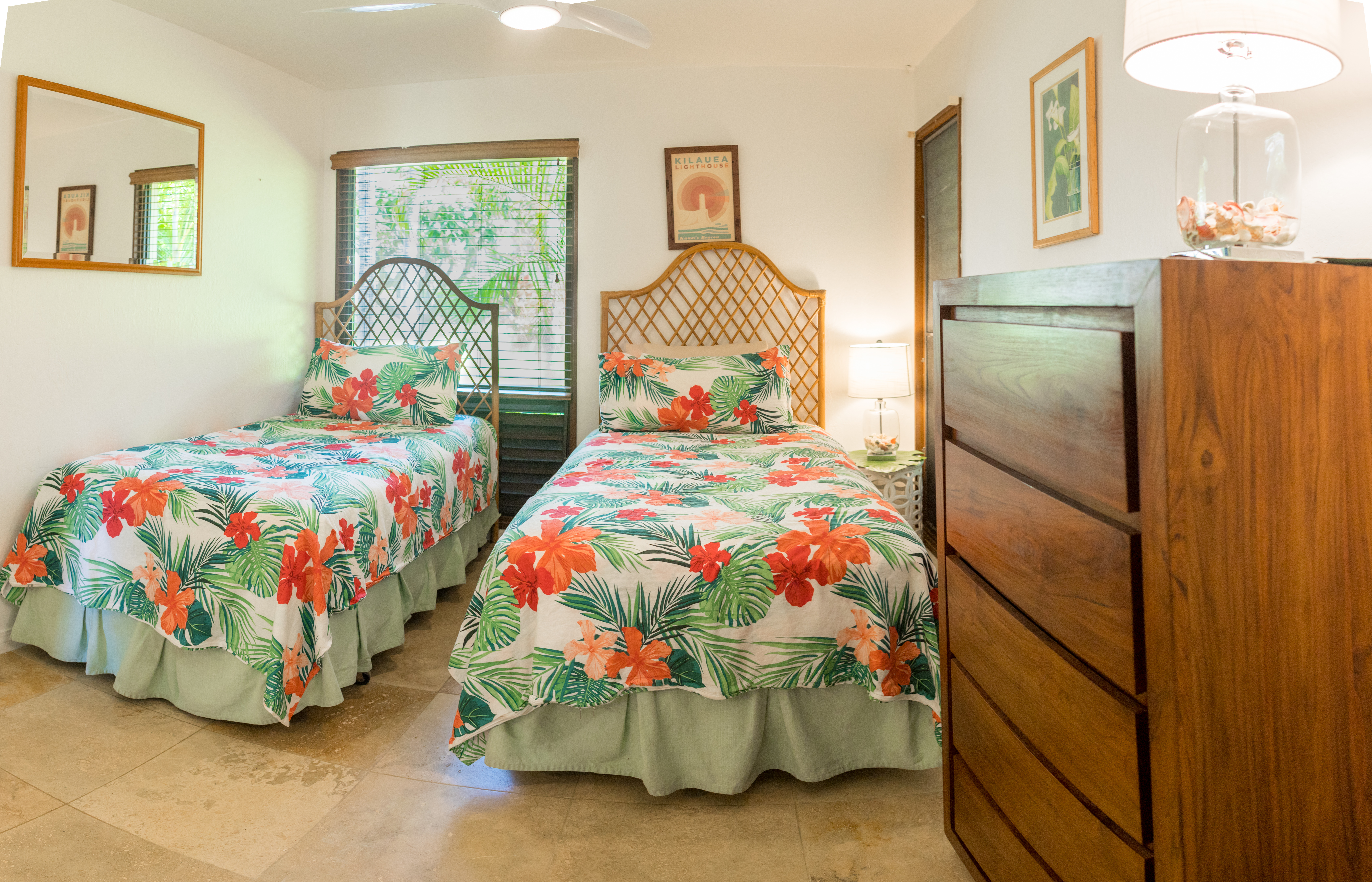 The second bedroom features two twin beds, large closet, dresser and full windows of lush greenery. 