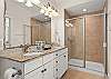 Primary bathroom with double sink vanity and walk in shower 