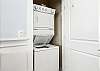 Stacked washer and dryer by entry door 