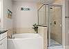 Soak tub and walk-in shower in primary bathroom 