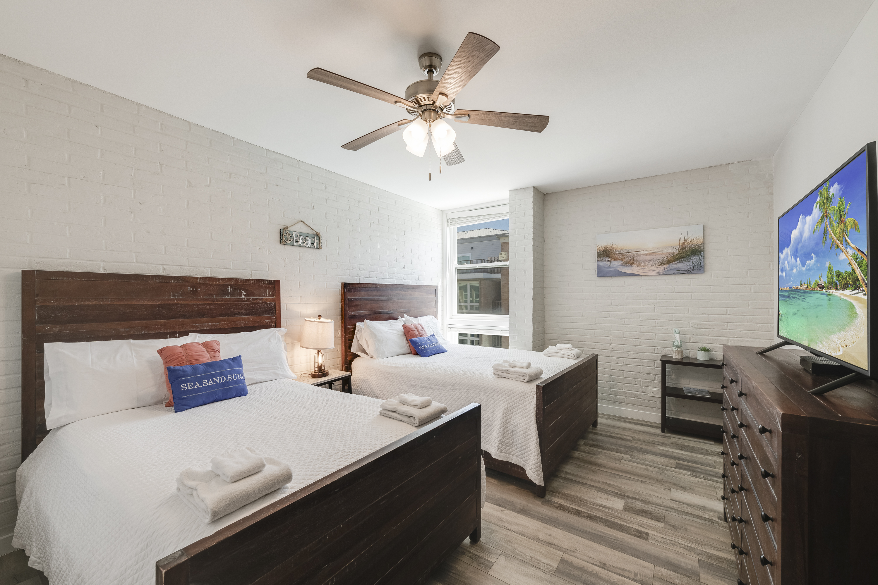 Charming spacious bedroom with 2 queen beds, flat screen TV and dresser for extra storage space