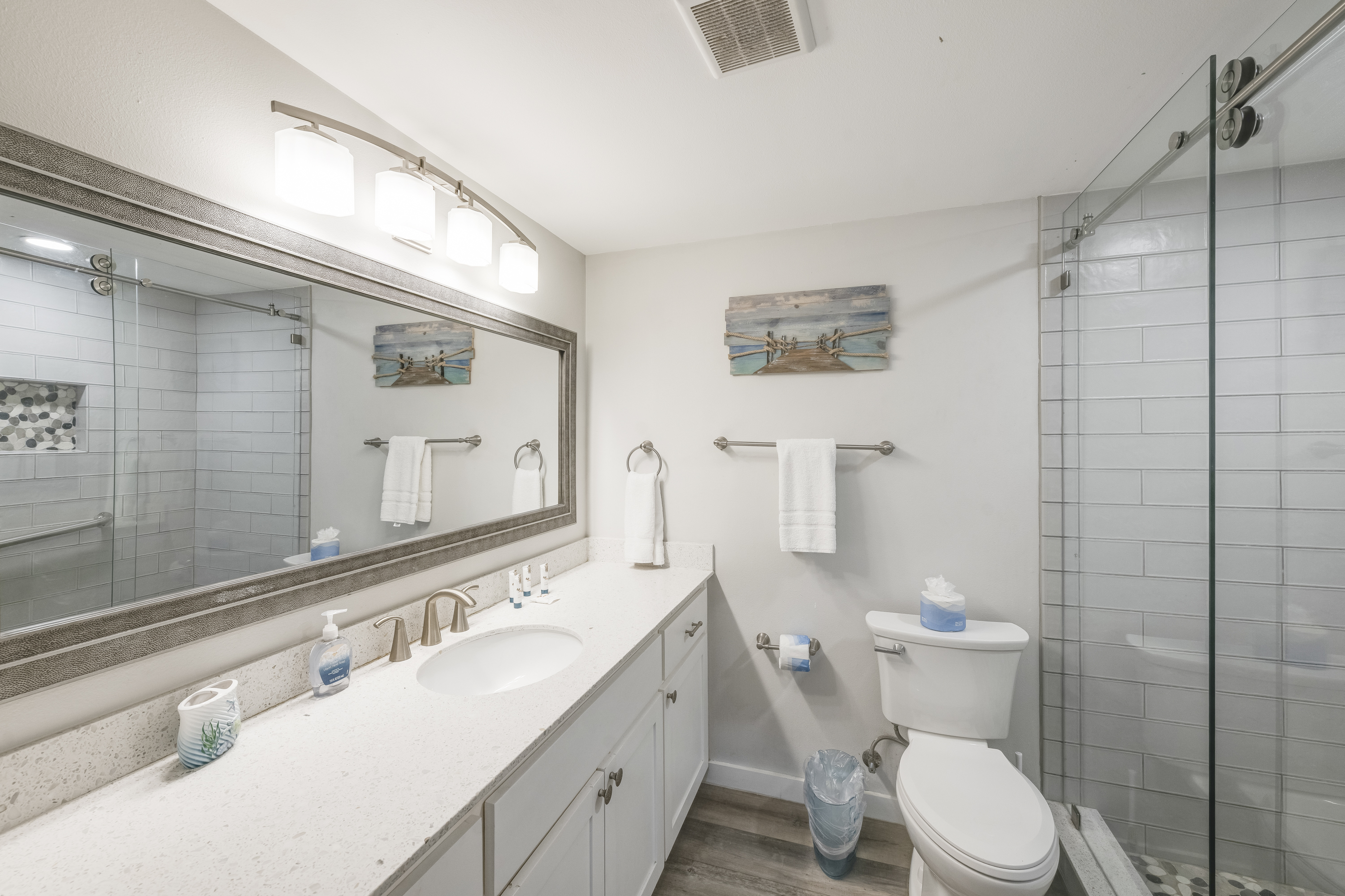 Spa like bath with walk-in shower, large vanity and wide framed mirror