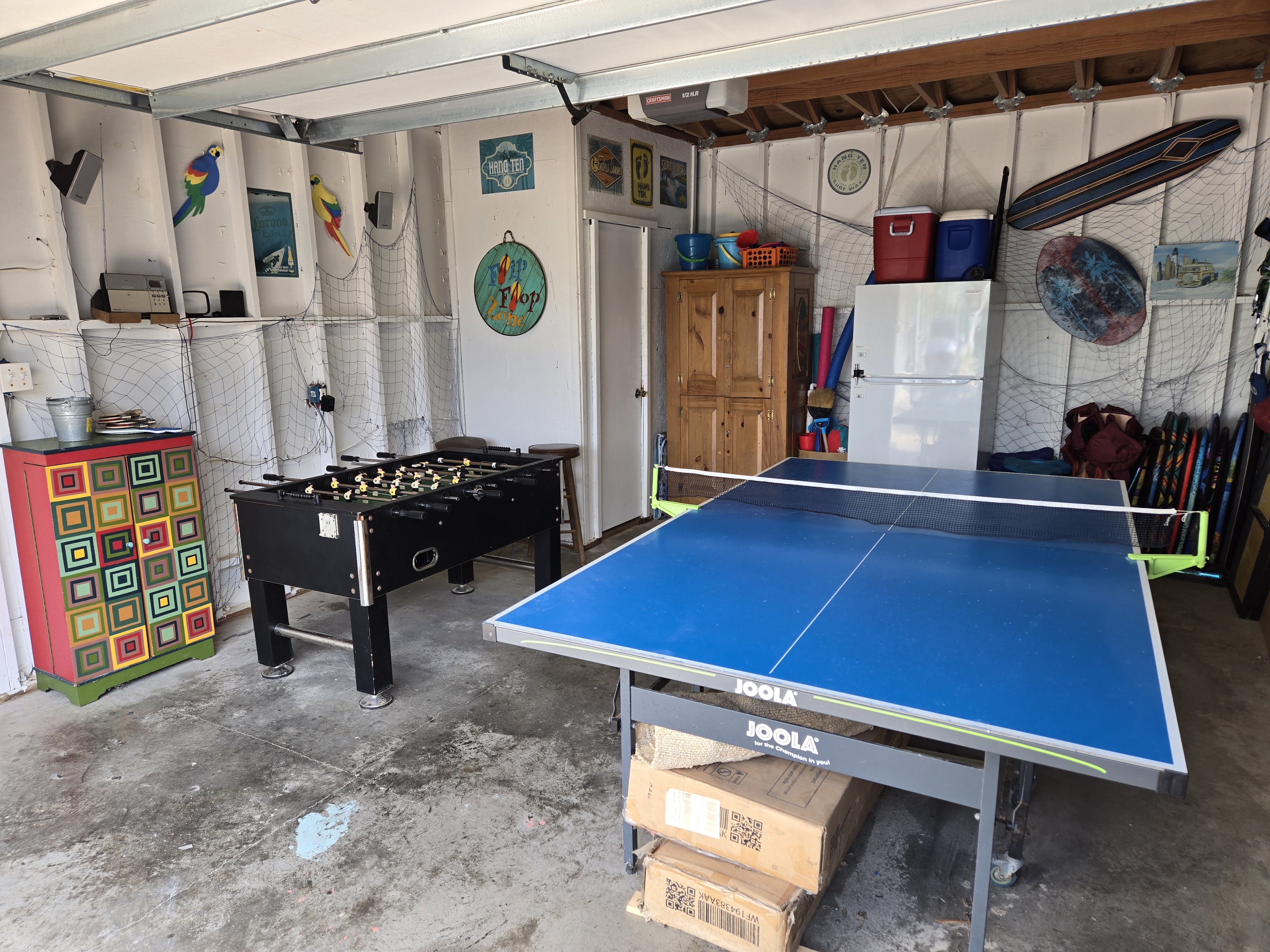 Game room in the garage with a ping pong table and fooseball.