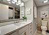 Stylish bathroom boasting a sleek toilet and contemporary sink with ample counter space 						