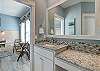 Beautiful tile work along this large single vanity in this en suite bathroom 