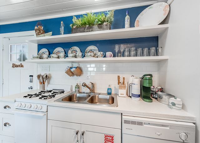 Kitchen fully equipped with cookware and dishware.