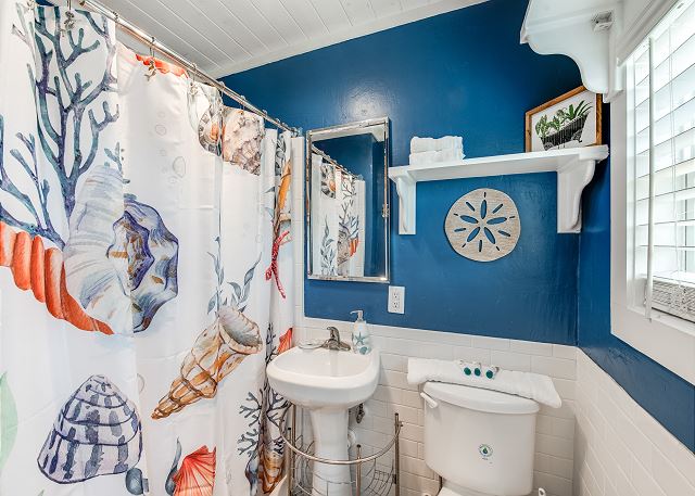 Bathroom with shower, pedestal sink, and toilet.