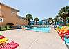 Community pool with cozy sunbeds, and tropical ambiance.