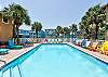 Inviting community pool with clear blue water, surrounded by comfy loungers