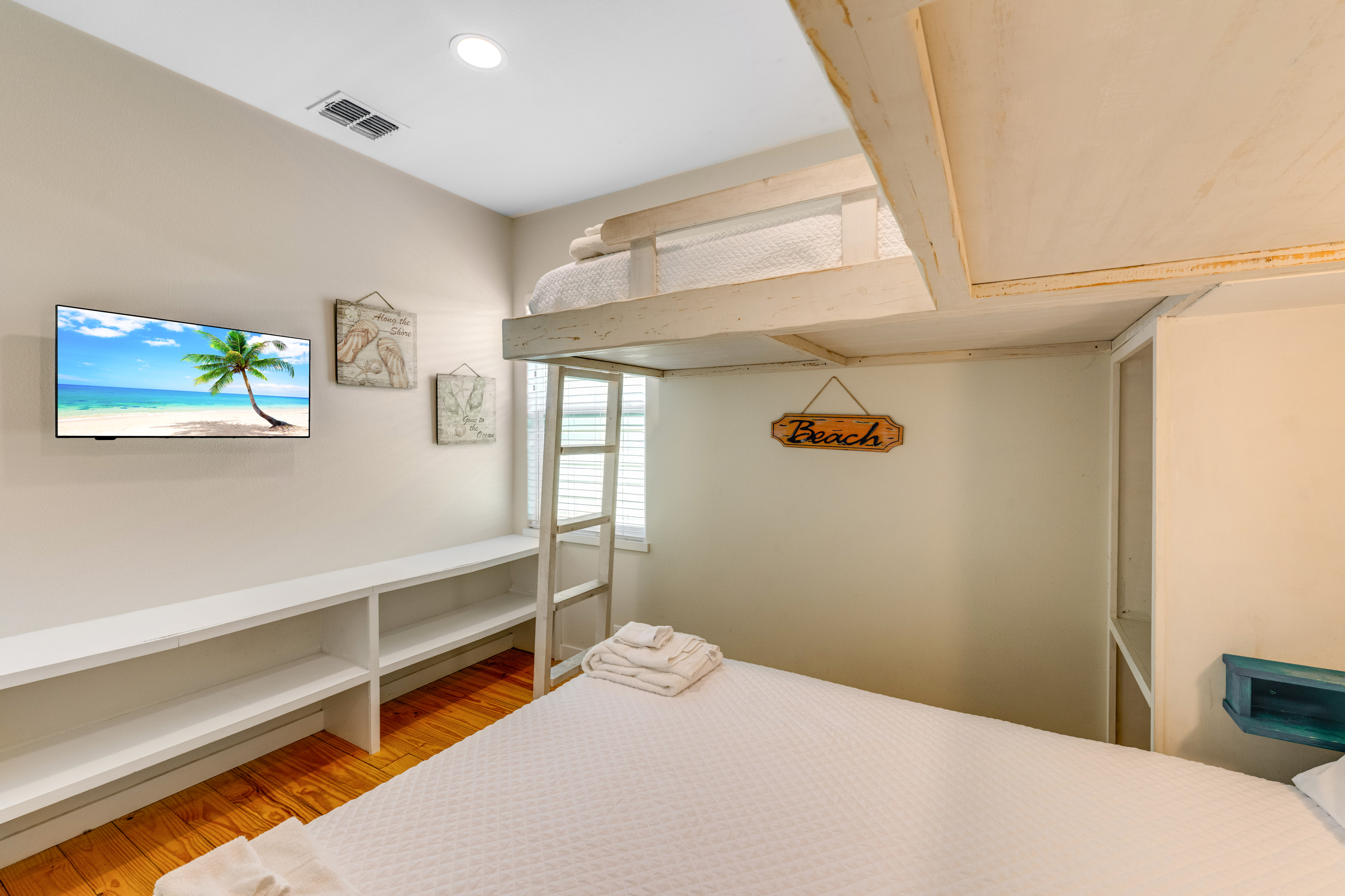 Queen bed and 2 lofted twin beds with built-in shelving keeps belongings organized and easy to access