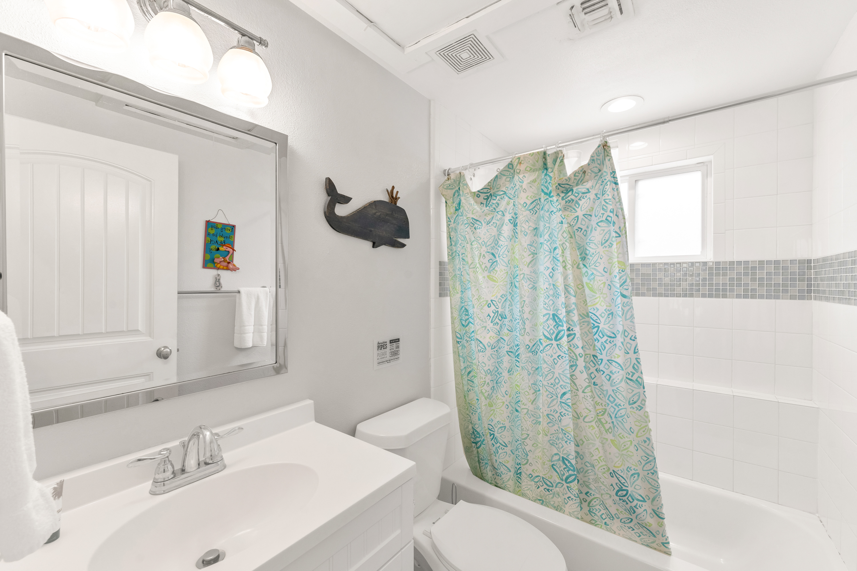 Freshly updated full bath with coastal charm, stocked with soft towels and all the essentials for your stay.