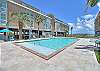 Inviting community pool with clear blue water, surrounded by comfy loungers