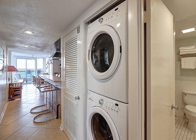 Washer and dryer in the hall leading to a bathroom 