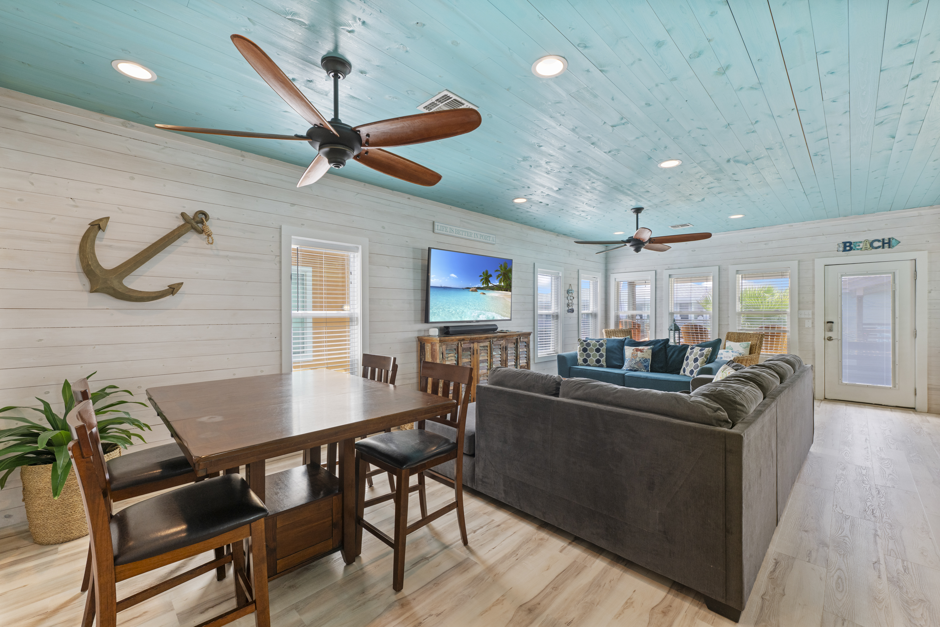The open-concept living and dining area provides a comfortable space for everyone to gather. The living room offers cozy seating and a TV for relaxing after a day of exploring, while the nearby dining table is perfect for enjoying meals, playing games, or