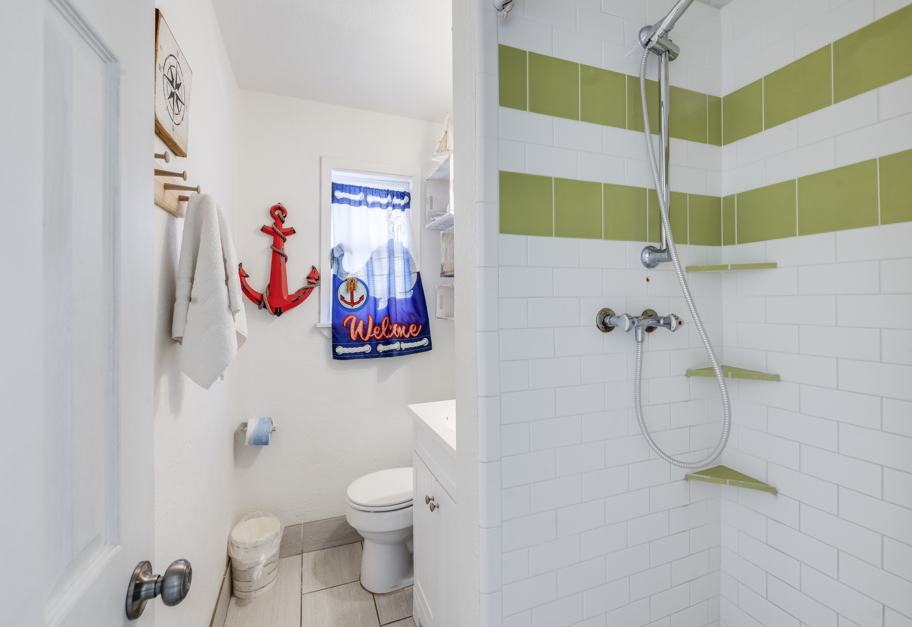 bright, beachy bathroom with cheerful nautical touches featuring a walk-in shower with low threshold 