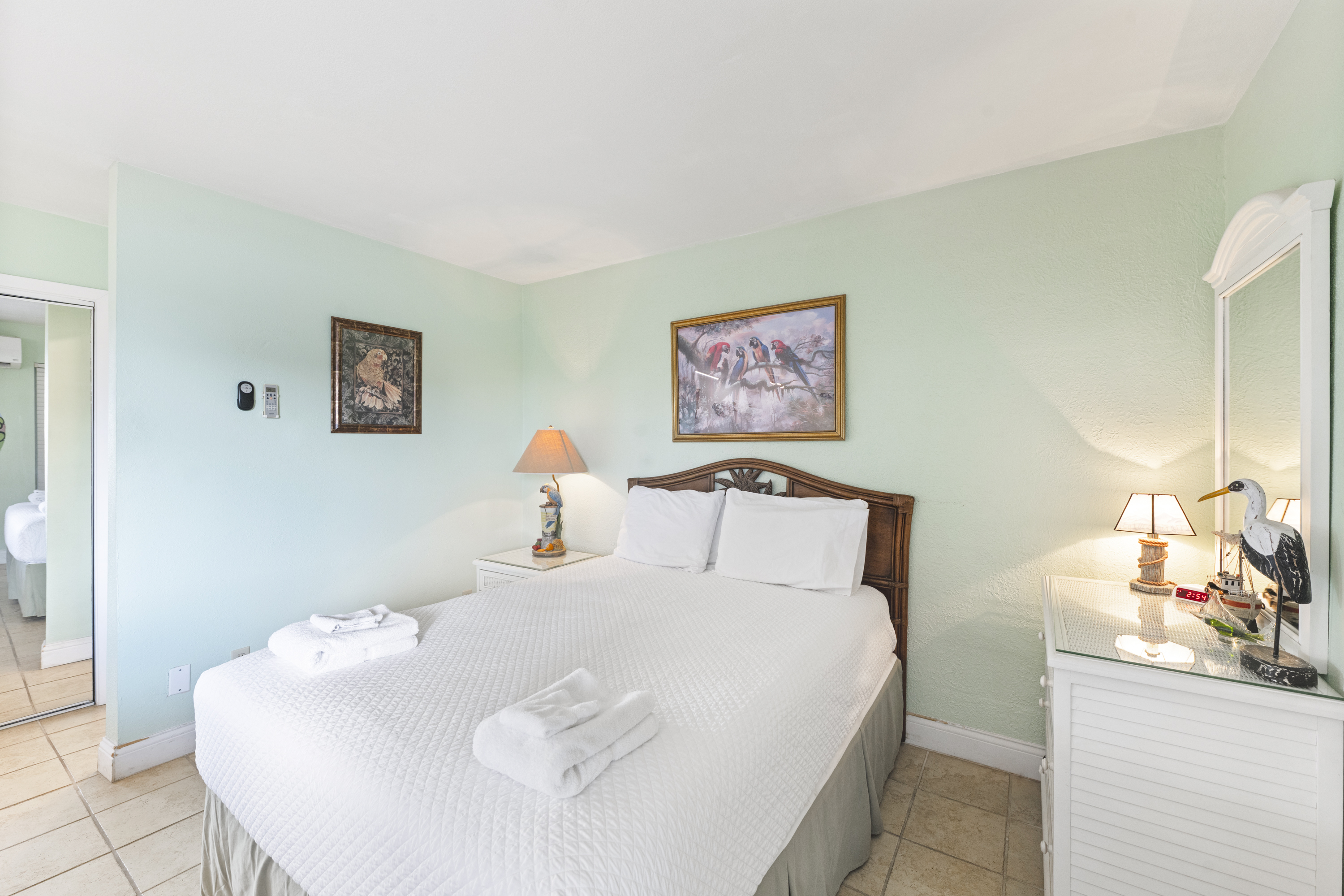 Relax in the charming coastal queen bed surrounded by open living, dining, and kitchen areas.