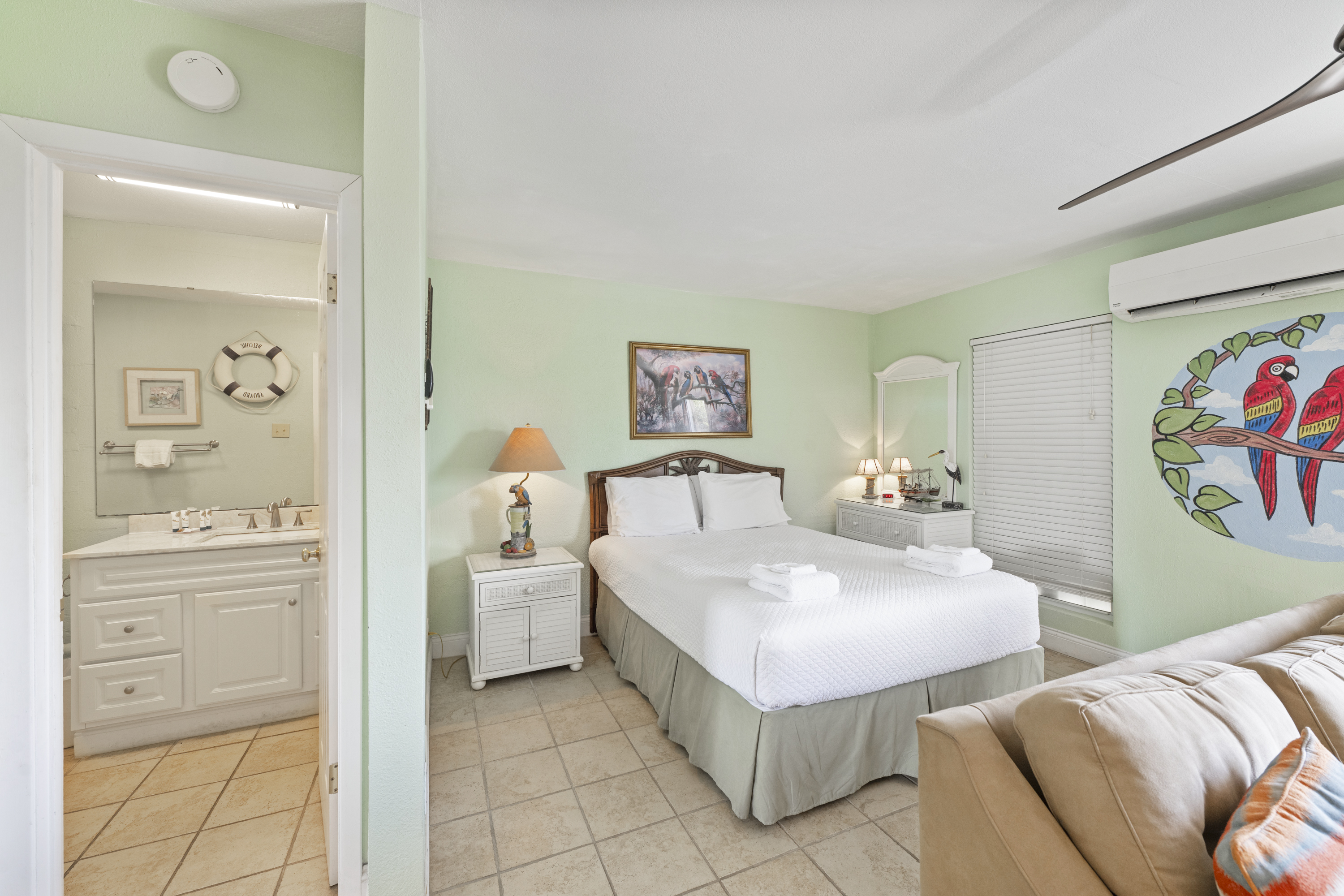 Queen-size bedroom with a glimpse of the large, functional bathroom vanity.
