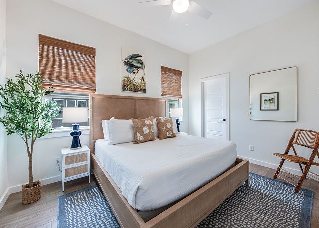 Primary Bedroom with King bed, TV, and ensuite bath with low-entry tiled shower