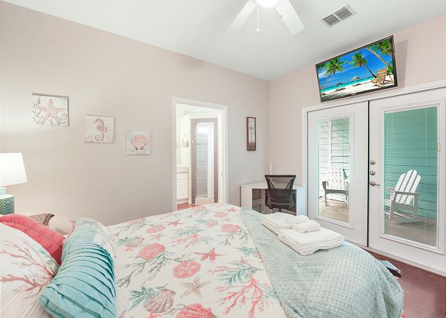 Primary Queen bedroom is your coastal retreat -Featuring patio access, corner desk nook, TV and en suite bath!