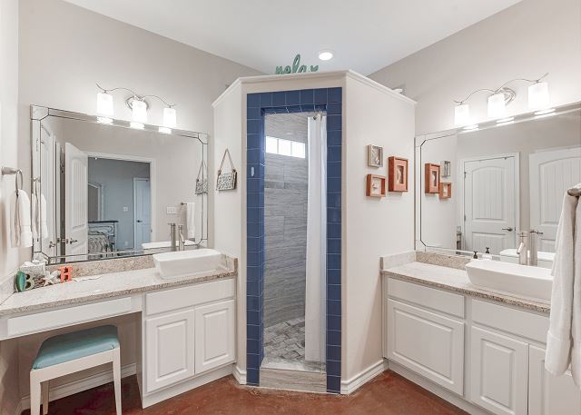 Primary Queen Suite's beautifully tiled walk-in shower and double vanity