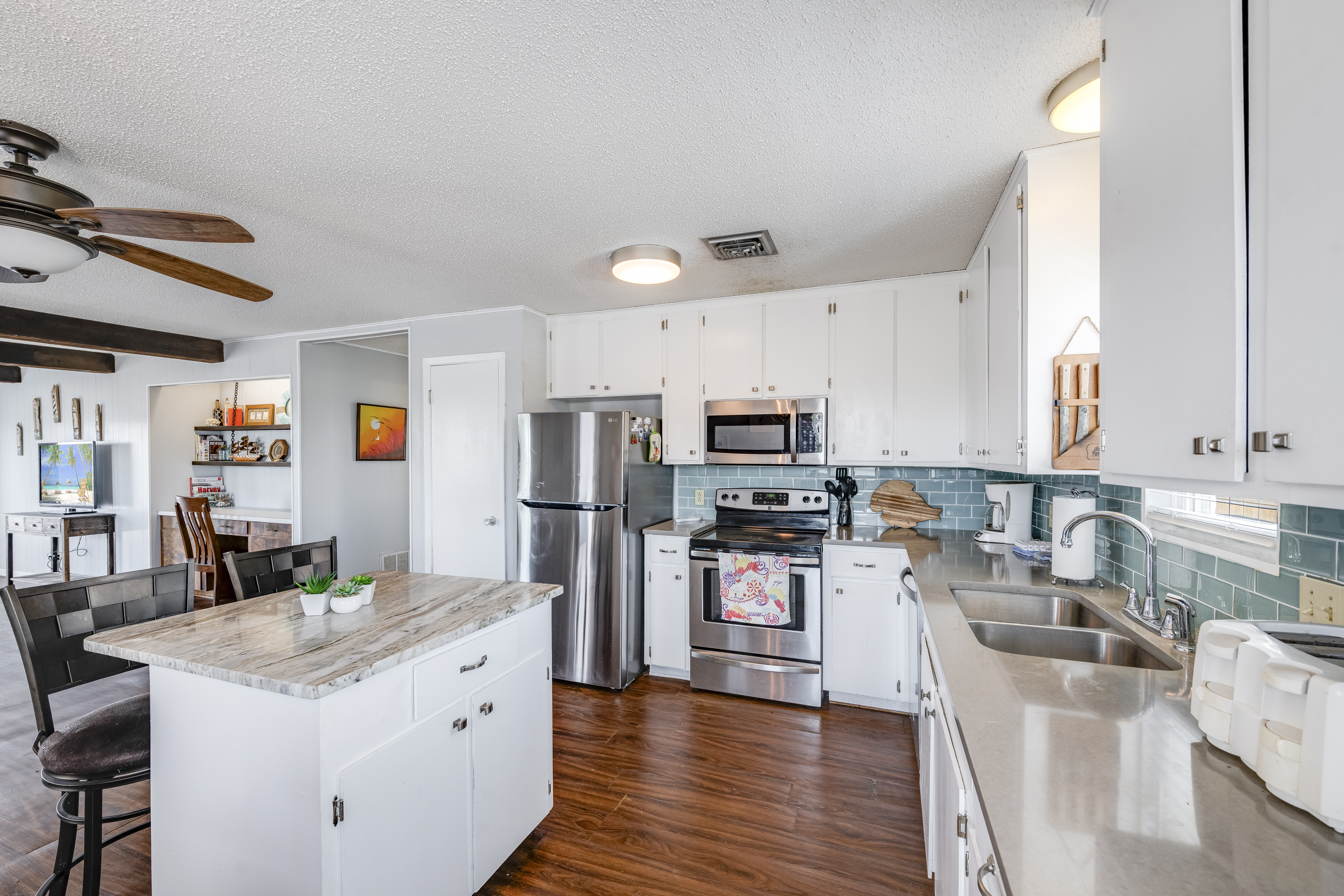 This inviting coastal kitchen offers a extended countertop space making meal prep and group cooking easy and enjoyable