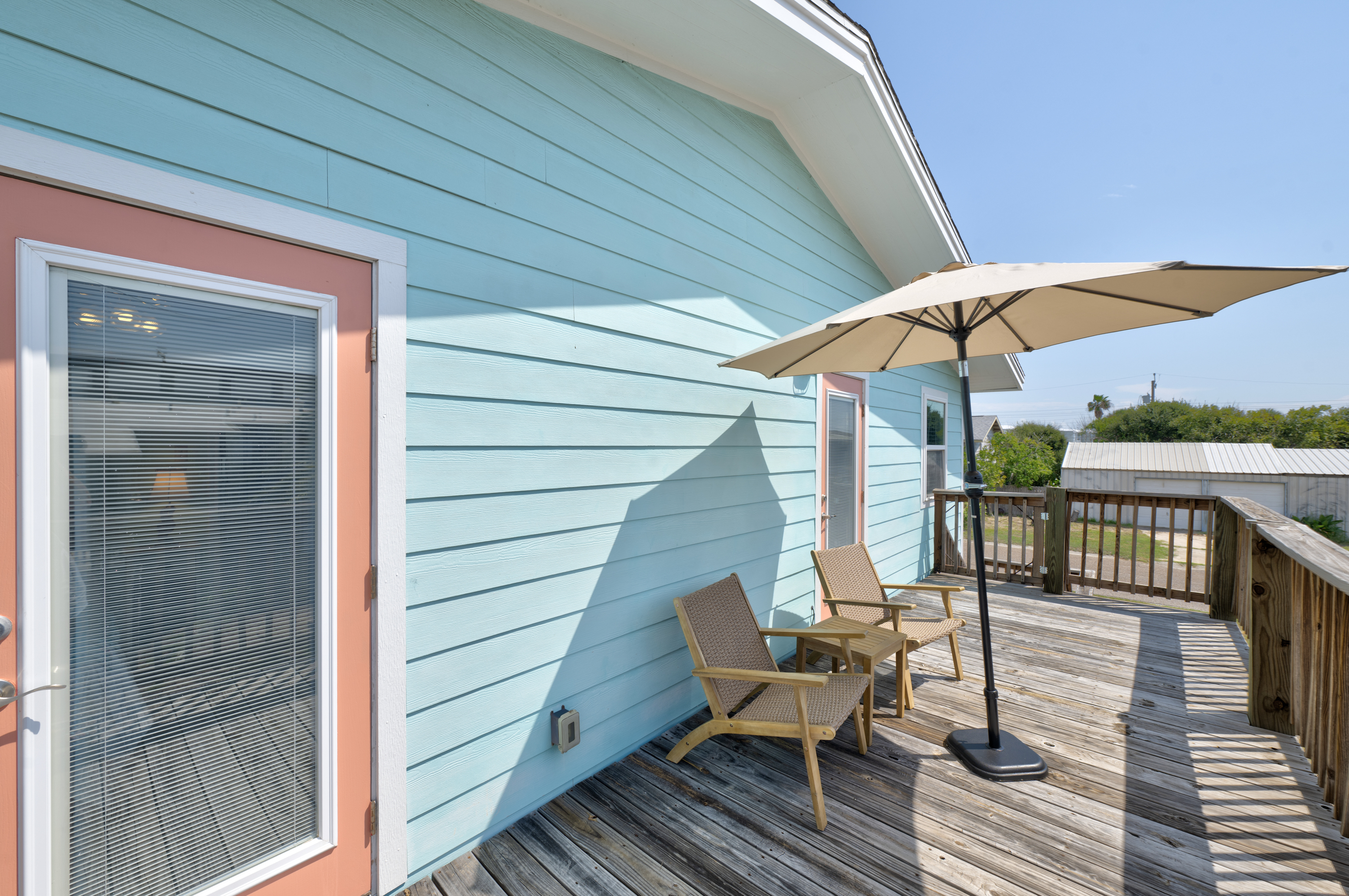 This charming upper deck offers the perfect blend of sun and shade with comfortable seating and a large umbrella for relaxing outdoors