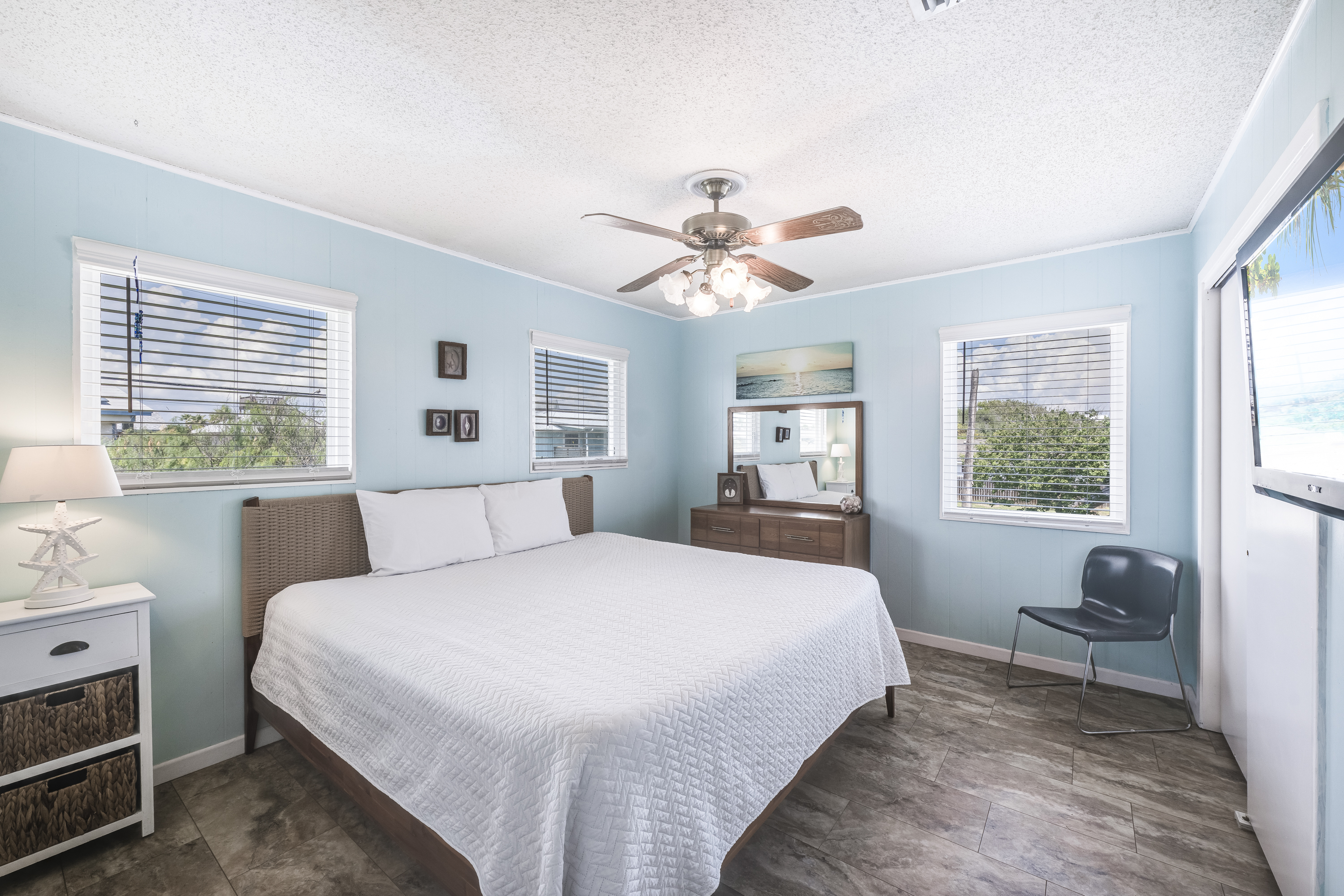 The spacious king bed anchors the room, while the dresser and mirror add warmth and practical convenience