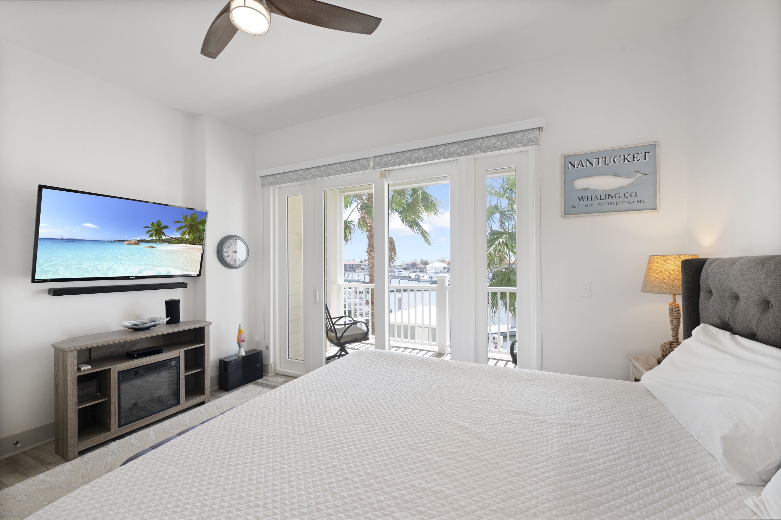Take in Marina Views form King Bedroom Suite which Offers Balcony Access and Mounted TV to Unwind. 