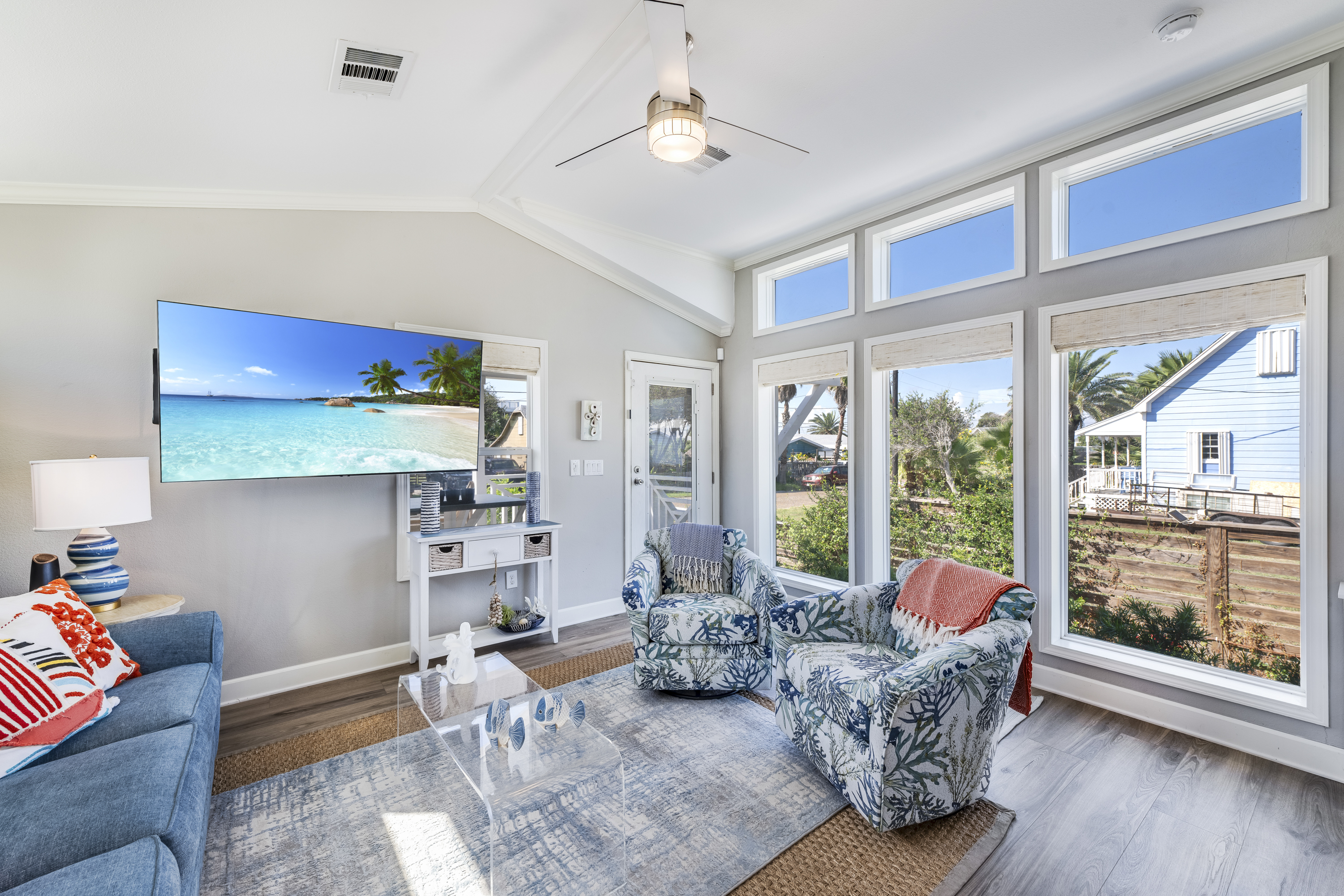 The spacious living area features large windows that frame beautiful panoramic views and coastal-inspired décor, creating a bright and welcoming place to relax together.