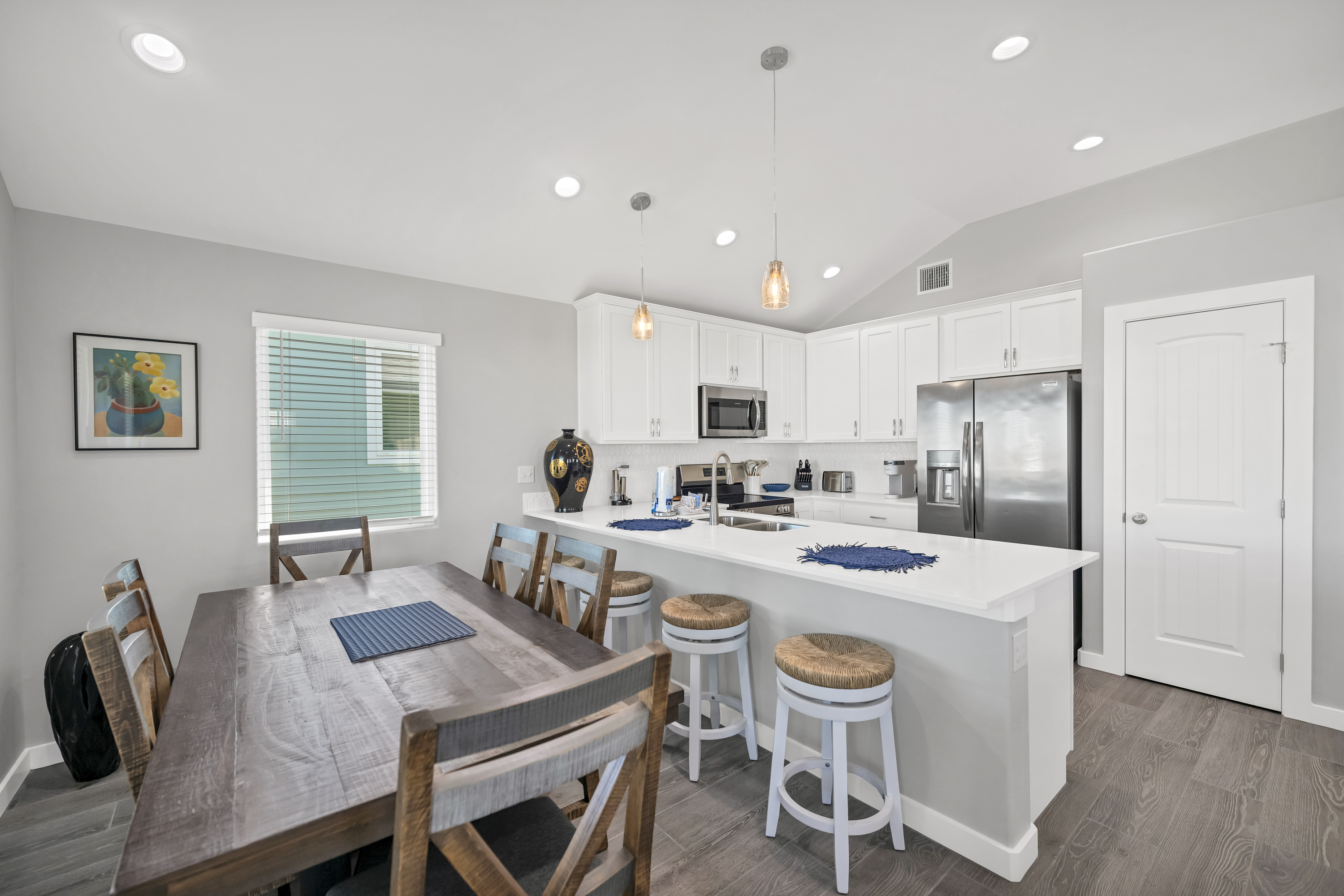 Enjoy a meal with family and friends at this spacious dining table with additonal seating at kitchen island