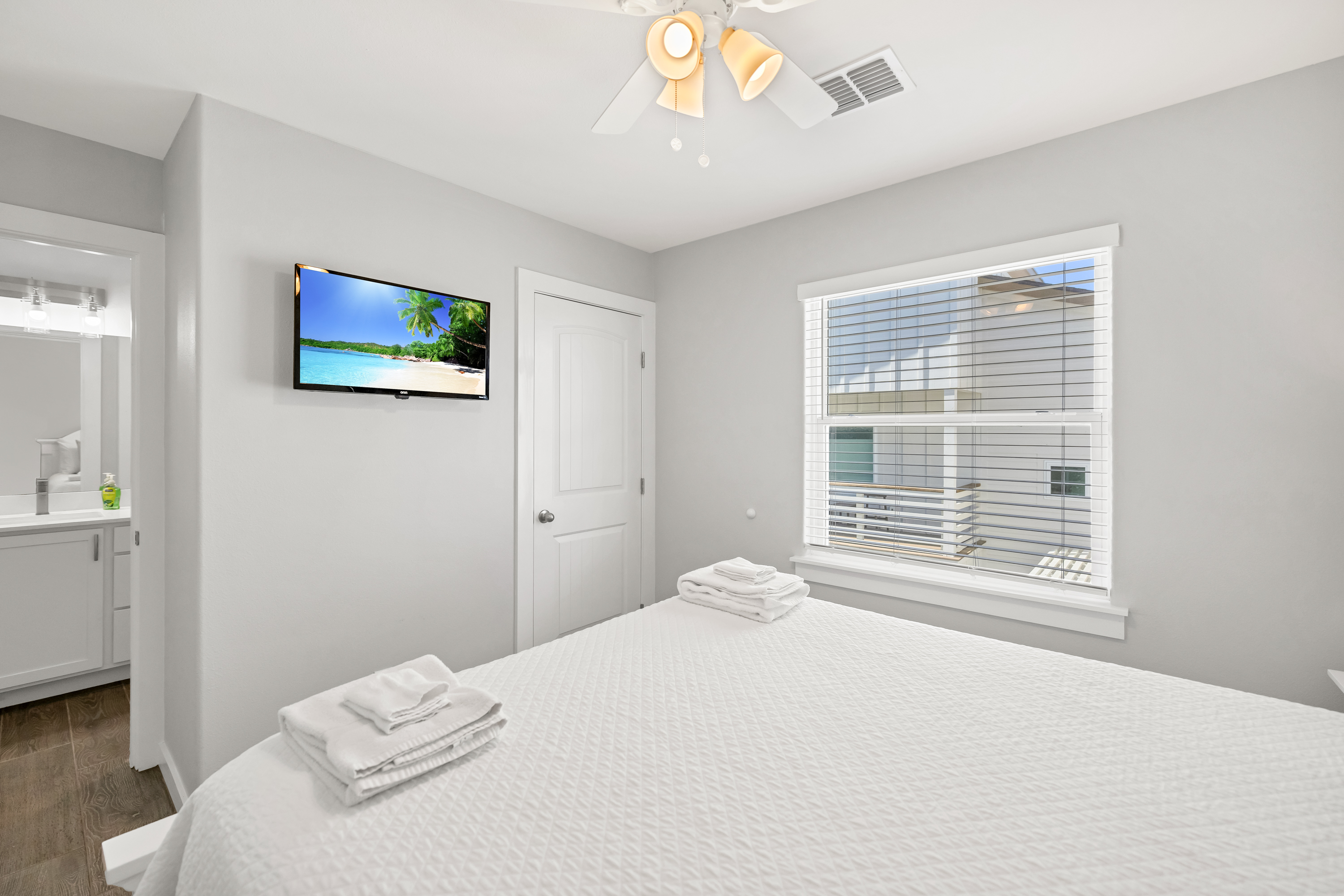 Inviting bedroom complete with a Queen-size bed, Mounted TV, and a stylish shared bathroom