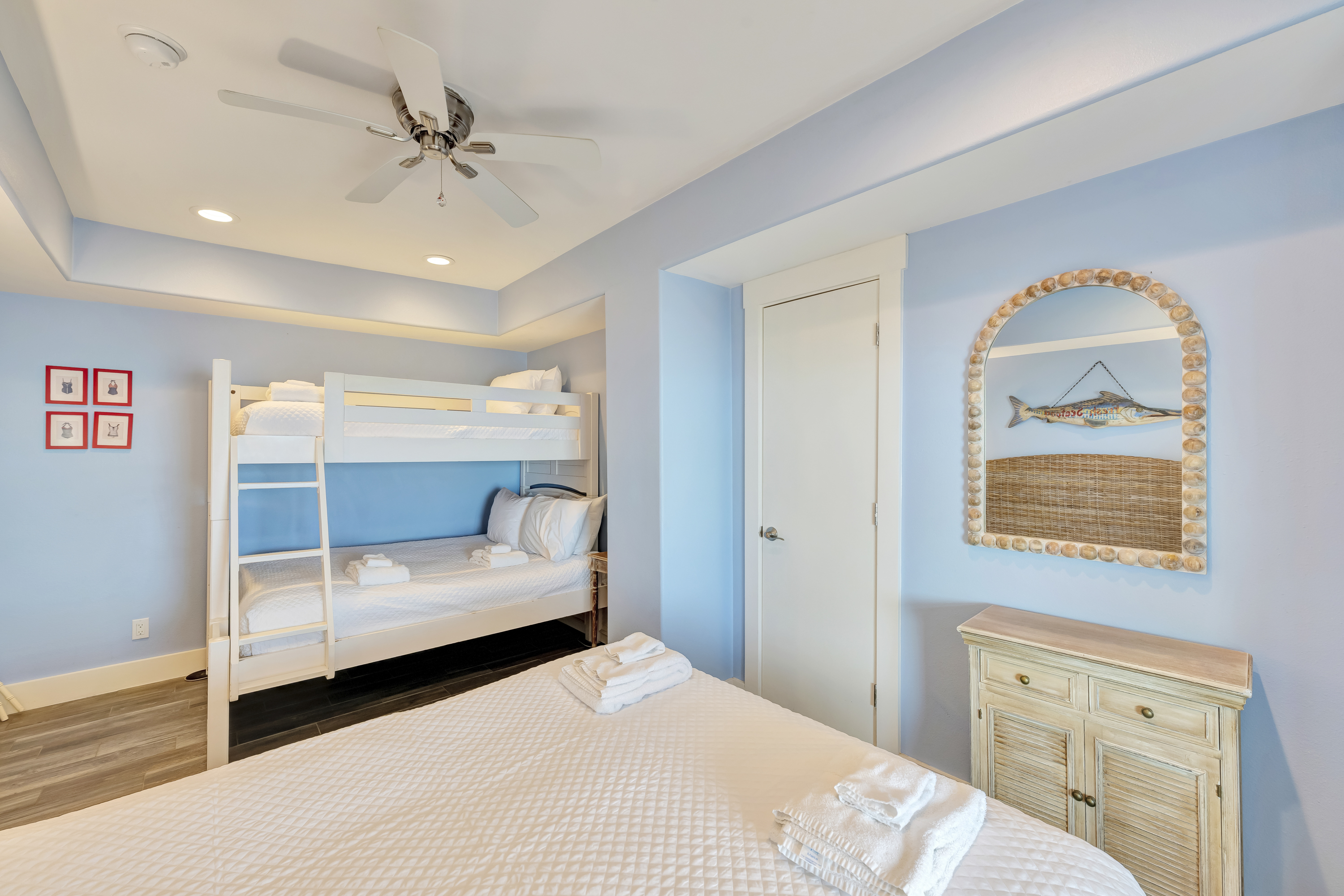 Spacious first-floor bedroom with plush queen bed and twin-over-full bunk bed for versatile sleeping