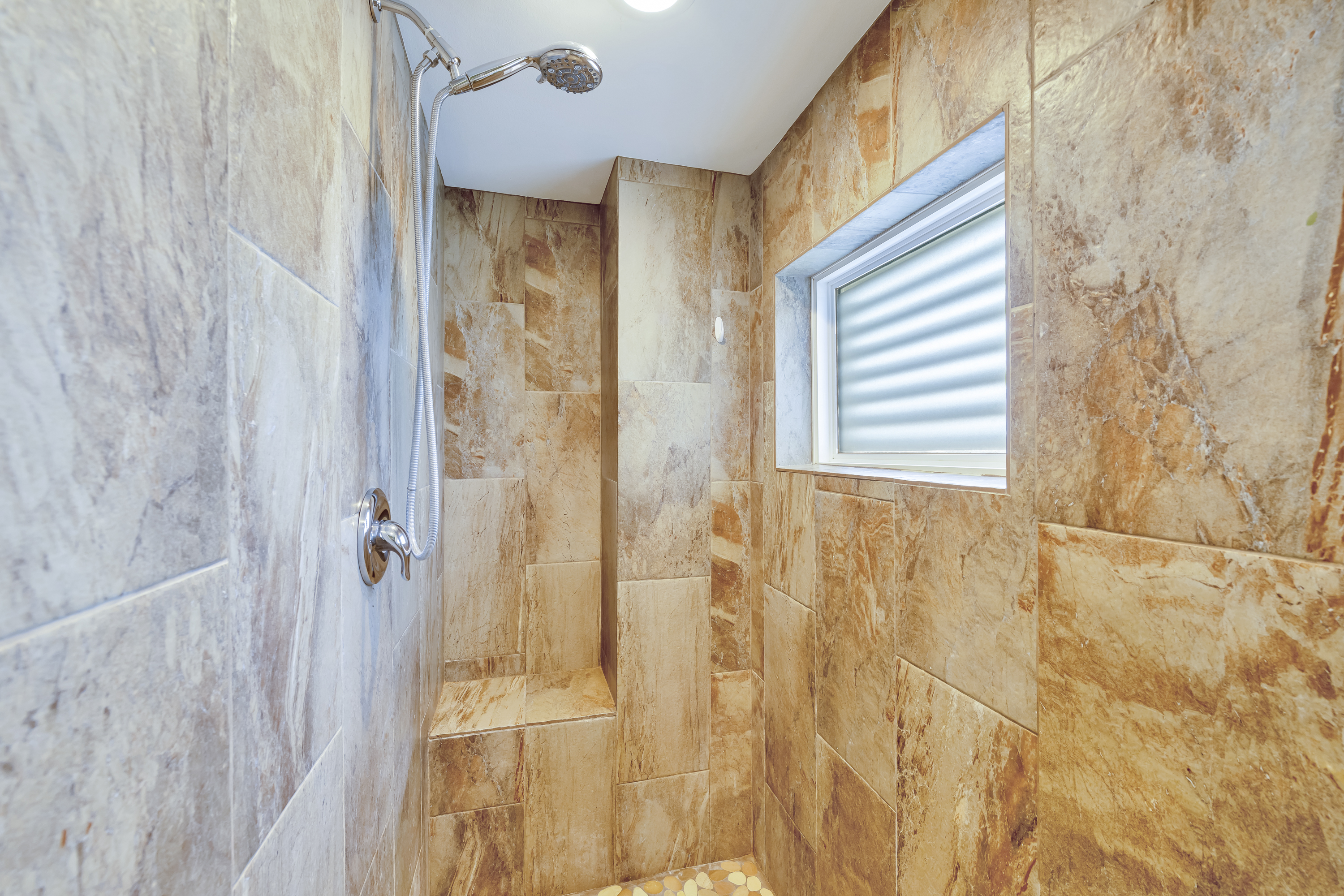 A spacious, tiled walk-in shower offering a clean, contemporary aesthetic