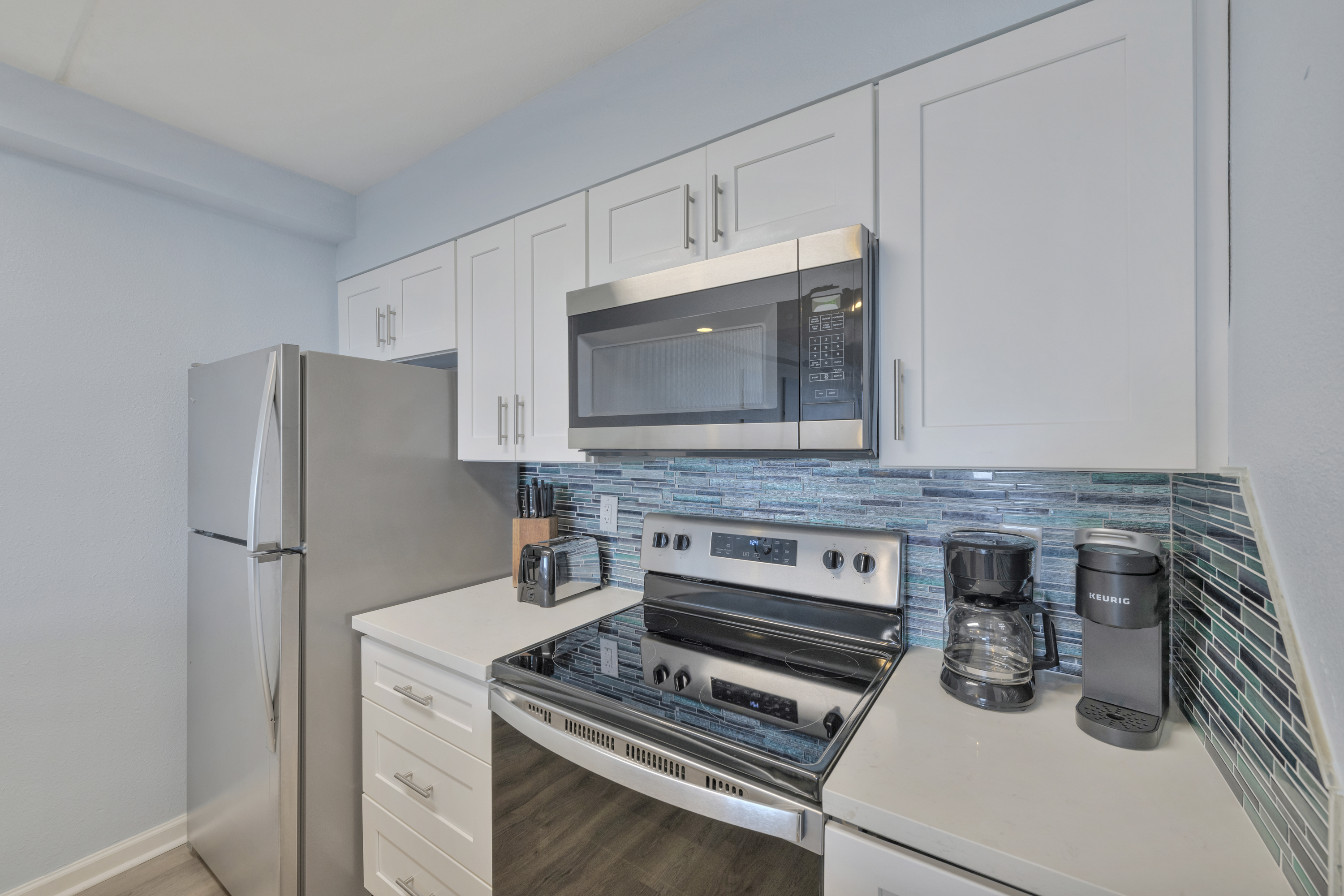 A modern, fully equipped kitchen with stainless steel accents and bright finishes—made for easy meals and laid-back mornings.