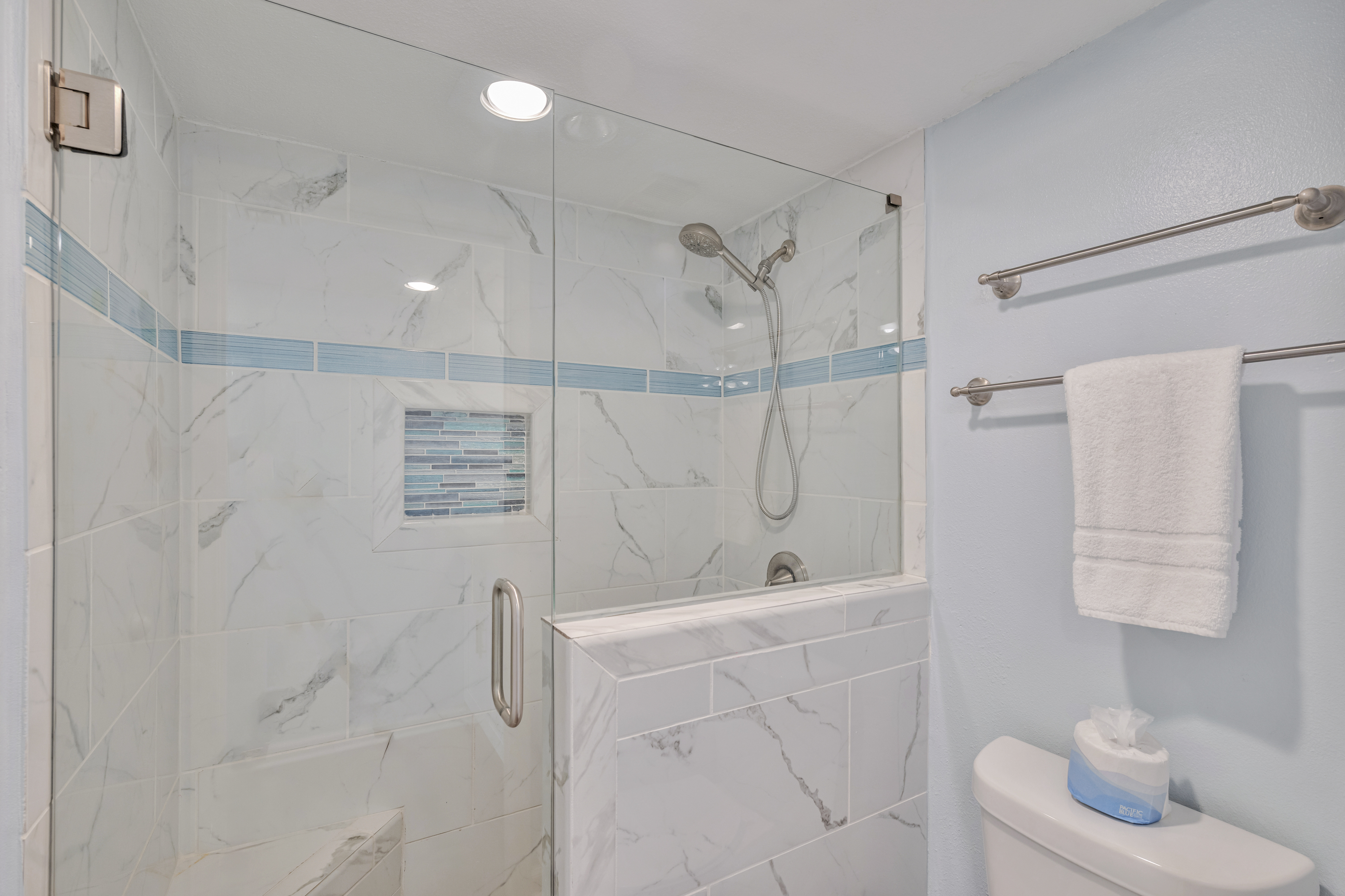 Enjoy an ensuite full bath featuring a beautifully tiled walk-in shower with a low threshold and built-in bench. This sleek, modern spa-like bathroom is designed for ultimate relaxation.