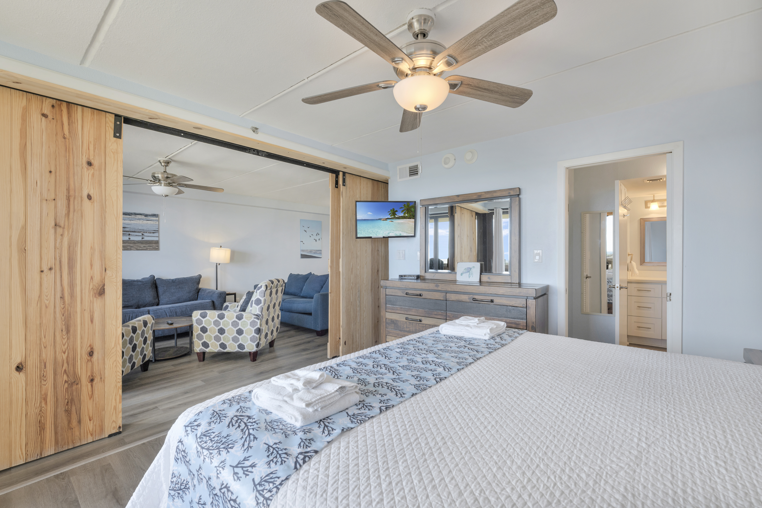 The primary bedroom features a king-size bed, mounted TV, and dresser—creating a space that truly feels like home.