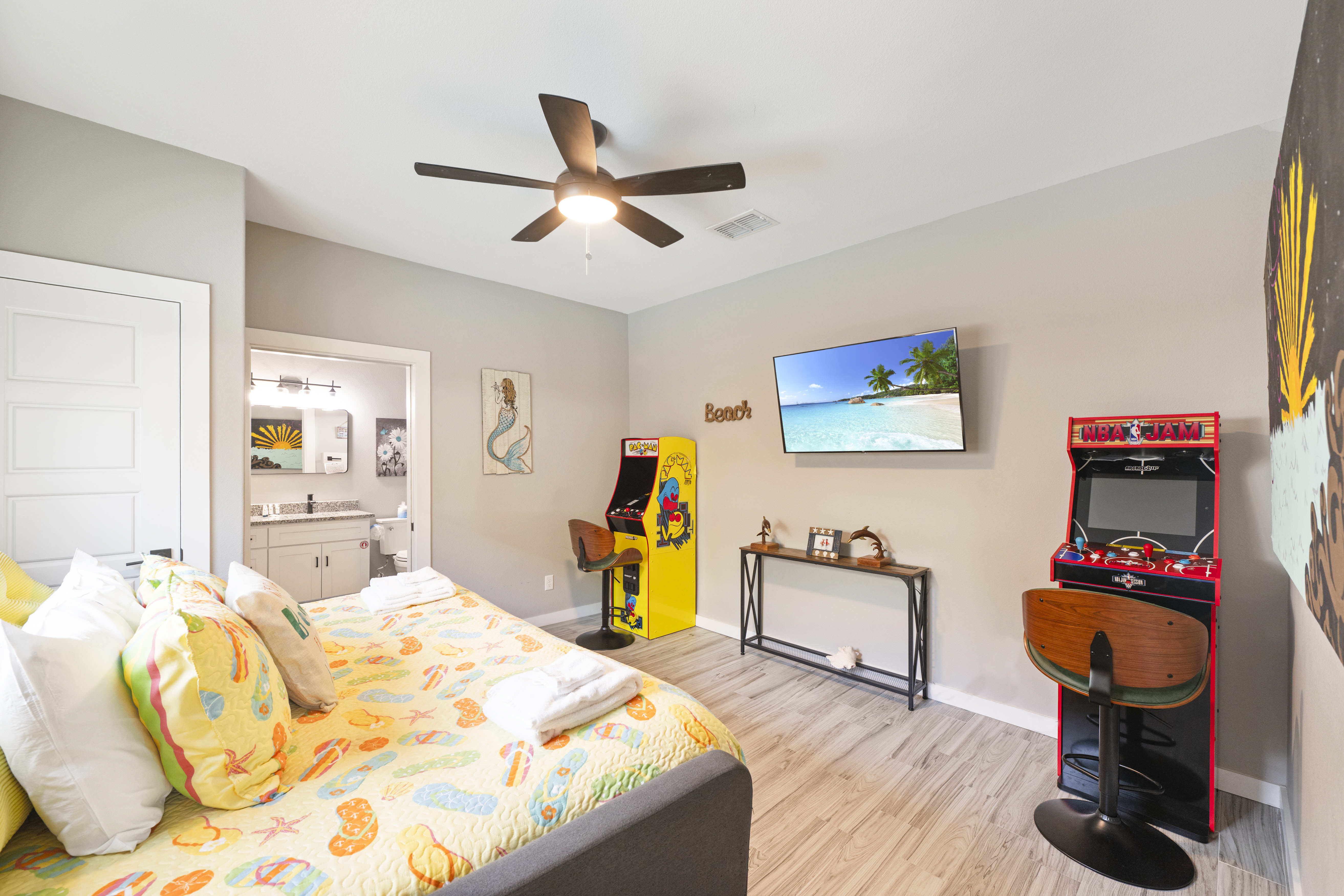 Full-size bed with a full trundle in the game room, featuring a mounted TV and private ensuite bath—ideal for family fun and relaxation.