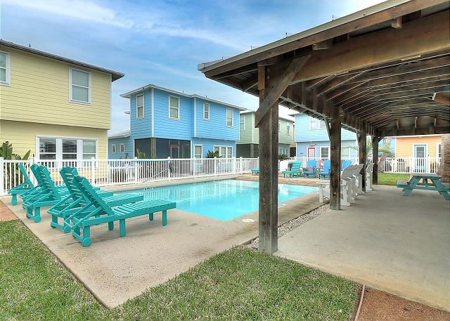 Community pool featuring covered patio with picnic table and seating