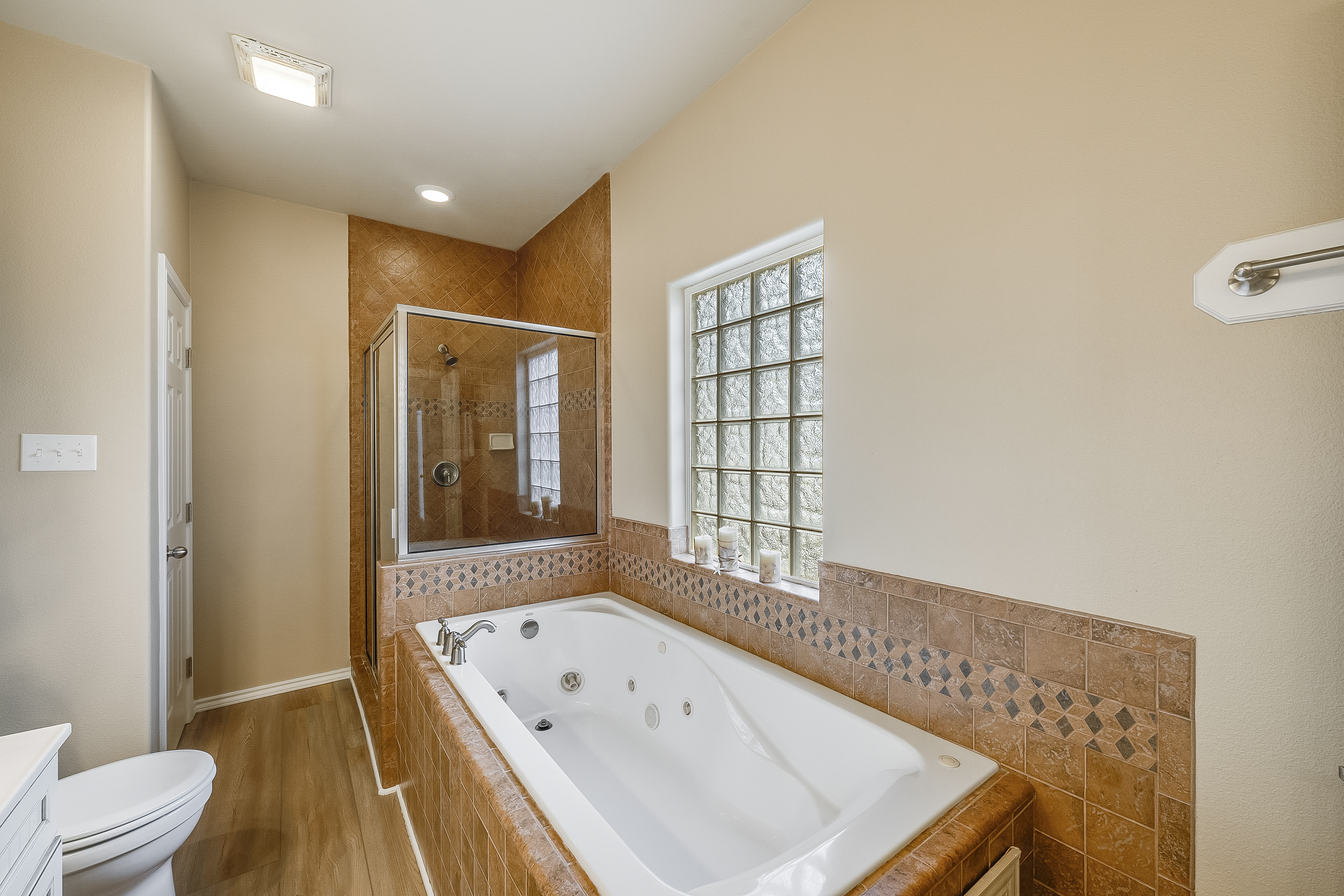This stylish full bath features a tiled walk-in shower, spacious vanity, and a calm, coastal color palette for a relaxing refresh