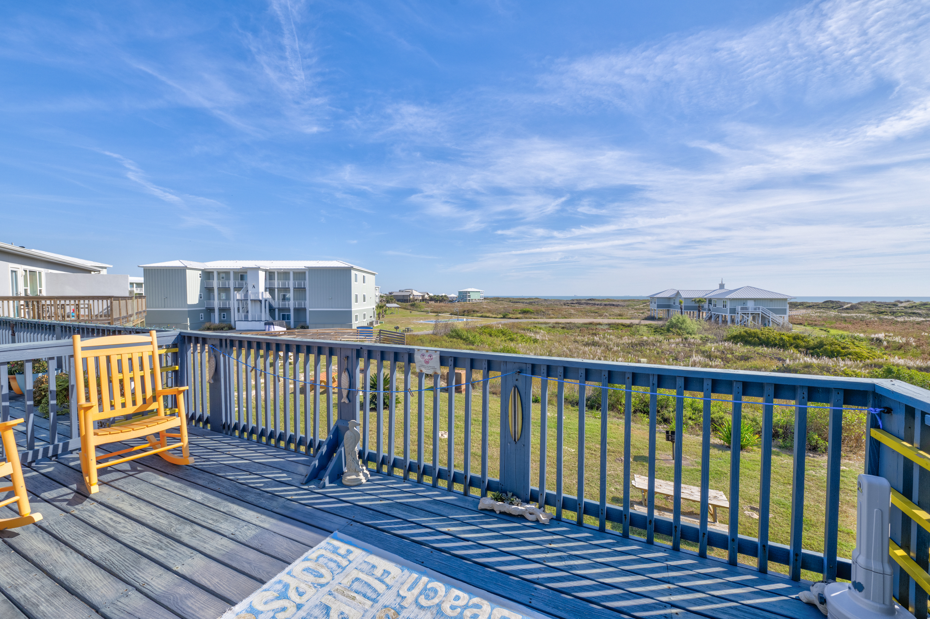 The living area opens to an oversized patio showcasing a stunning view of the beach.