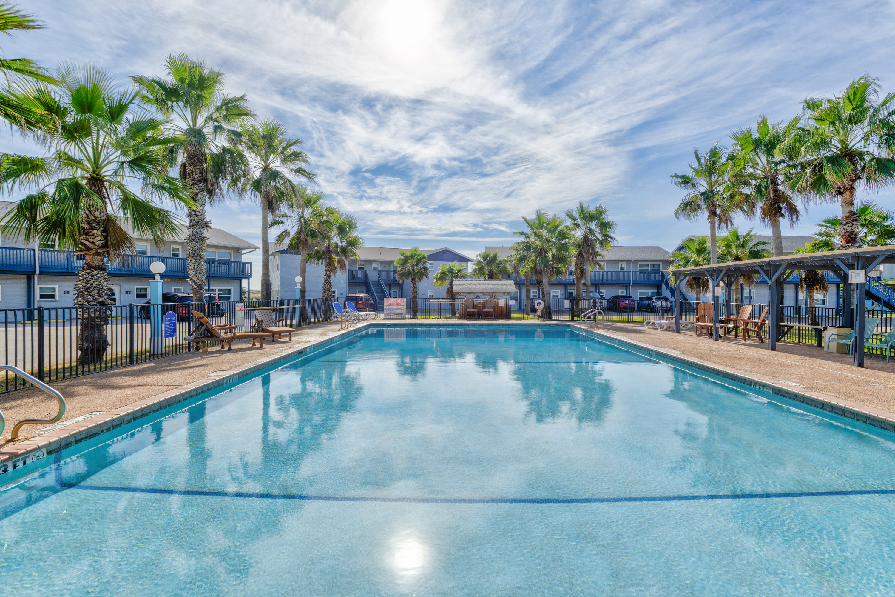 Relax by the community pool, surrounded by a lush tropical atmosphere and cozy sunbeds.