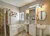 Luxurious primary en suit bathroom with double pedestal vanitites 