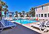 Inviting community pool with clear blue water, surrounded by comfy loungers 