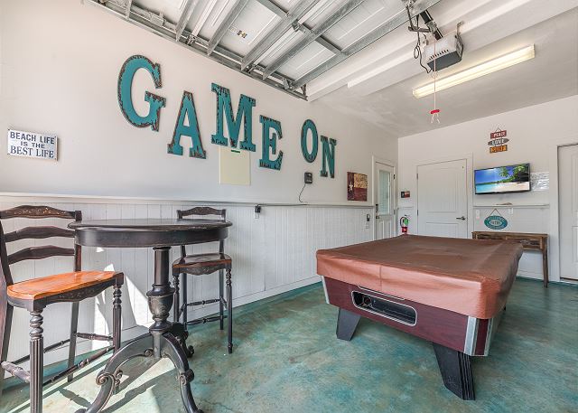 Garage with pool table, TV, and arcade game