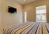 Bright and cheerful - 2nd Bedroom with a King Bed balcony access and mounted TV for convenience 