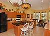 Fully equipped kitchen with island & bar. The breakfast nook offers pool view