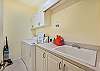 The laundry room is equipped with a large sink and washer & dryer.